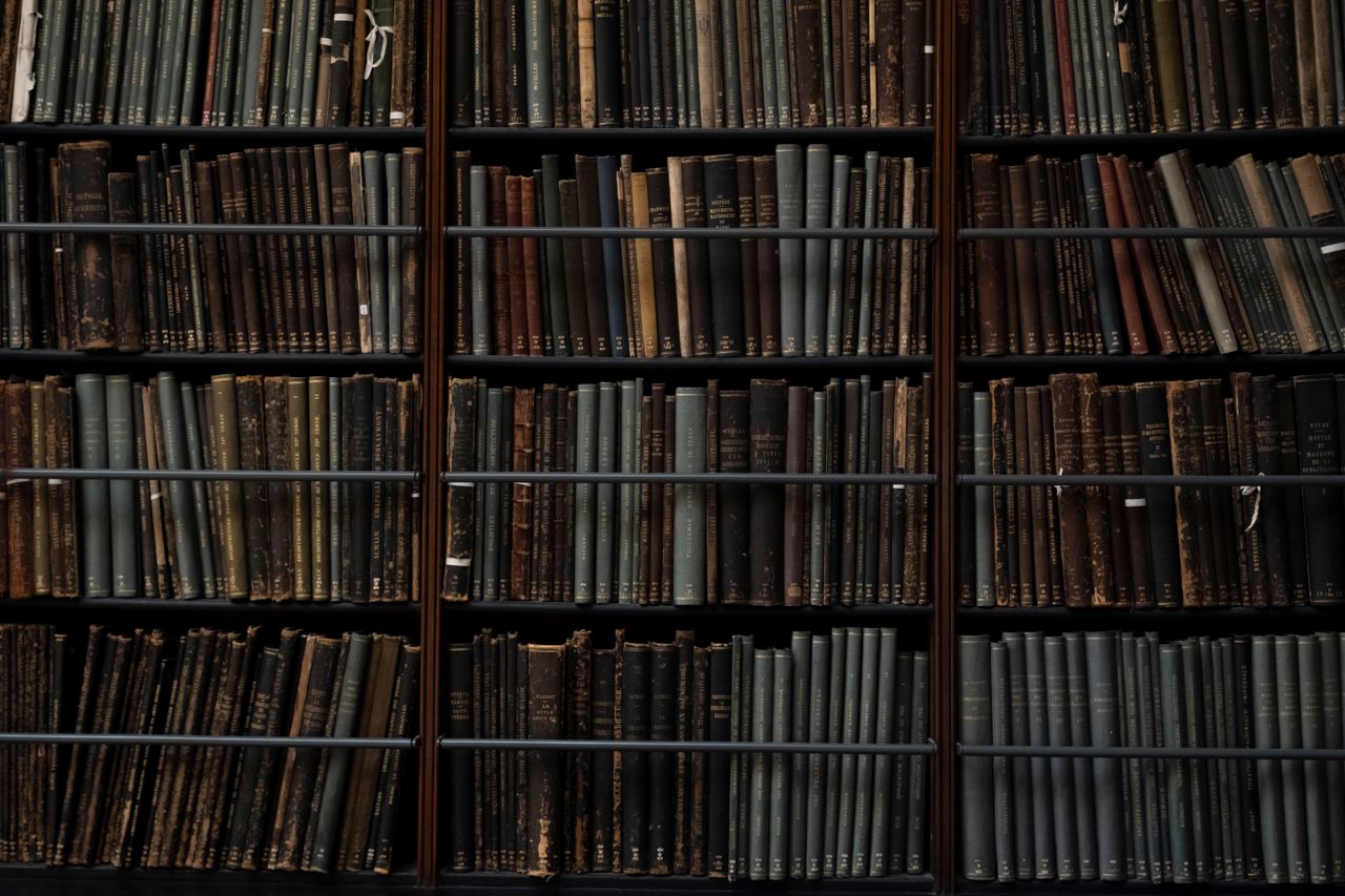 about-us-img A close-up of vintage books on library shelves in London, showcasing an abundance of literary history.