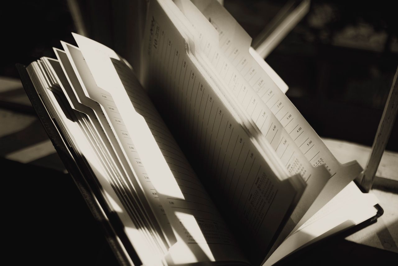 our-services-01 Shiny pages of agenda with lines and shadows on sunny day on blurred background